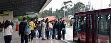 Usuarios esperando  la llegada de un bus de TransMilenio en un  portal del Sistema