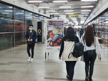 Usuaria visualizando un cartel de cine en estación Museo Nacional